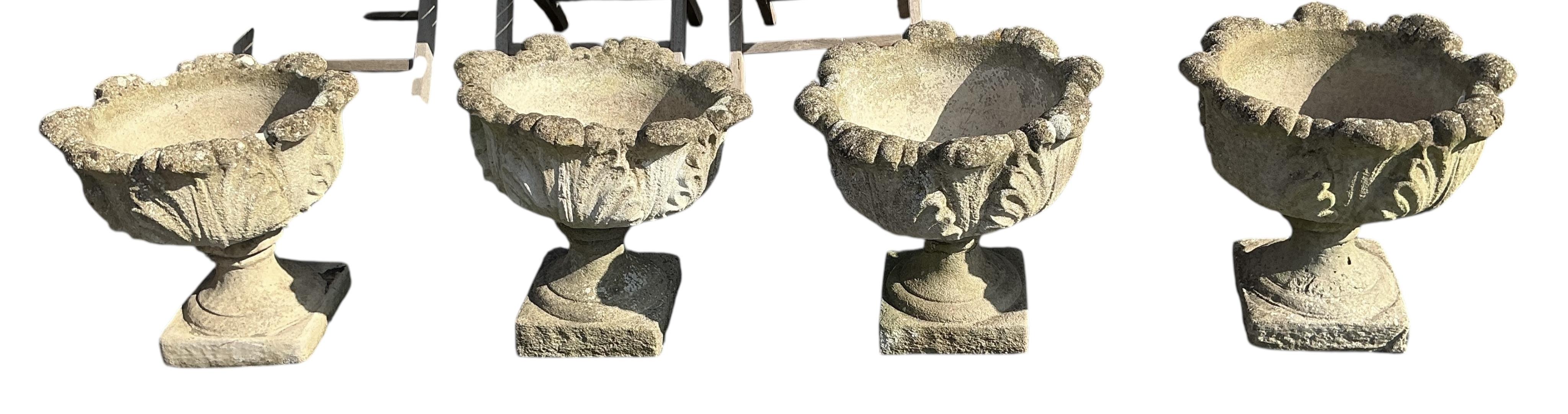 A set of four circular reconstituted stone garden planters, diameter 48cm, height 46cm